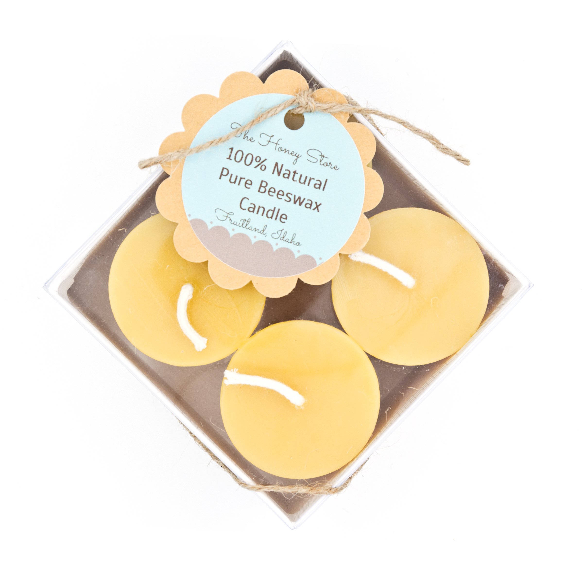 The+Honey+Store+-+BeeswaxCandle_4pk_1817 Three natural beeswax candles packaged in a clear box, labeled "100% Natural Pure Beeswax Candle" from The Honey Store in Fruitland, Idaho. The candles feature a soft yellow color and cotton wicks, ideal for eco-friendly home decor and ambiance.
